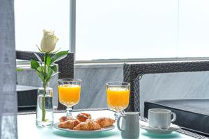 a table with two glasses of orange juice and pastries at Athenian Riviera Hotel& Suites in Athens