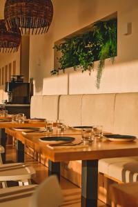 a restaurant with wooden tables and white chairs at Golden Tulip Porto-Vecchio in Porto-Vecchio