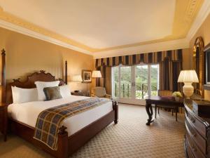 a hotel room with a bed and a balcony at Fairmont Grand Del Mar in San Diego
