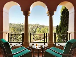 a balcony with two chairs and a table and a view at Fairmont Grand Del Mar in San Diego