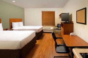 Habitación de hotel con 2 camas y escritorio en WoodSpring Suites Louisville Jeffersontown, en Louisville