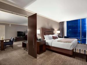 a hotel room with a large bed and a desk at Fairmont Pittsburgh in Pittsburgh