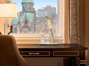 a table with a bottle on it next to a window at Fairmont Chateau Laurier in Ottawa