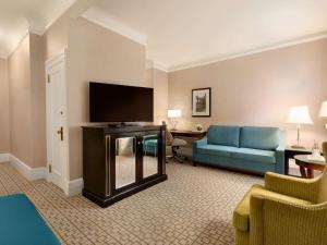 a hotel room with a couch and a flat screen tv at Fairmont Chateau Laurier in Ottawa