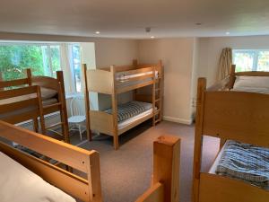 a room with two bunk beds and a table at Stonehenge Hostel - YHA Affliated in Amesbury