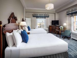 a hotel room with two beds and a television at Fairmont Empress Hotel in Victoria