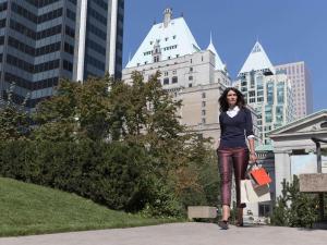 a woman standing in front of a tall building at Fairmont Hotel Vancouver in Vancouver