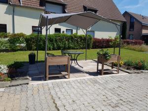 a patio with a table and an umbrella at Ferienwohnung Zur Alten Gärtnerei in Hürtgenwald
