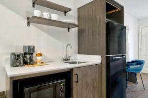 a kitchen with a sink and a microwave at Studio 6 Waco Downtown Baylor in Waco