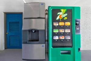 a green vending machine next to a blue door at Studio 6 Waco Downtown Baylor in Waco