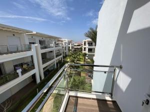 - Balcón con vistas a un edificio en Résidence RAMOFLORES - Appartement avec piscine - Sidi Rahal, en Sidi Rahal