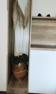 une boîte en bois avec un vase recouvert de plumes dans l'établissement Studio City day, à Jagodina