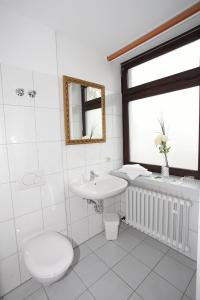 ein Badezimmer mit einem WC, einem Waschbecken und einer Badewanne in der Unterkunft Hotel Laacher Lay in Mendig