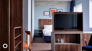 a living room with a television and a bedroom at Grandi by Center Hotels in Reykjavík