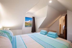 a bedroom with a large bed with blue pillows at Alpine Escape - Elevated Views with Spa in Queenstown