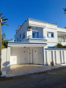 una casa blanca con un garaje delante en Superbe étage de villa vue sur mer en Nabeul