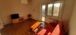 a living room with a red couch and a tv at Casa Felix Ostia in Lido di Ostia