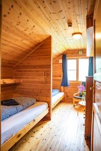a log cabin with two beds in a room at Guesthouse / Huskyfarm Innset in Innset