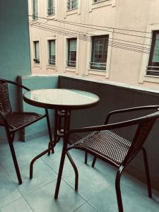 ein Tisch und zwei Stühle auf einem Balkon in der Unterkunft Ergosuites in Figueira da Foz