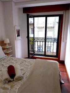 1 dormitorio con cama y ventana grande en Apartamento en casco antiguo Pi y Margal, en Vigo