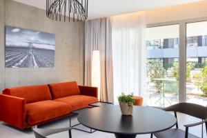 a living room with an orange couch and a table at Villa Castellane in Gréoux-les-Bains