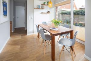 uma sala de jantar com uma mesa de madeira e cadeiras em Mühlenloft em Norderney