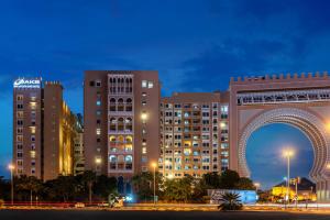 a large building with a clock on the side of it at Oaks Ibn Battuta Gate Dubai in Dubai