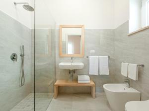 ein Badezimmer mit einem Waschbecken, einem WC und einem Spiegel in der Unterkunft Ammarèa B&B in Torre San Giovanni Ugento