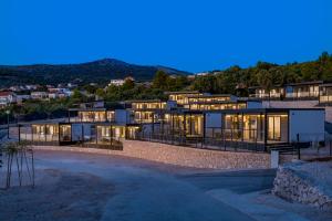 普利莫顿CAMP ADRIATIC MOBILE HOMES - PRIMOŠTEN的夜晚山顶上的房子