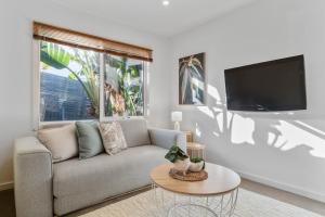 uma sala de estar com um sofá e uma televisão de ecrã plano em Seaford Luxe Beach House 2023 BDC Traveller award winner em Seaford