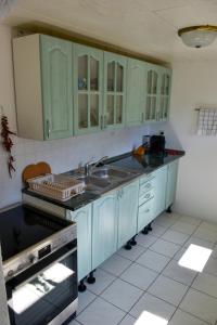 a kitchen with blue cabinets and a sink at Gemenc Vendégház Baja in Baja