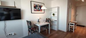 a room with a desk and a tv and a table and chairs at Labo Apartment Bagno Palace of Culture View in Warsaw