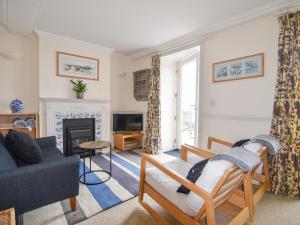 een woonkamer met een bank en een open haard bij 5 St Michaels House in Lyme Regis