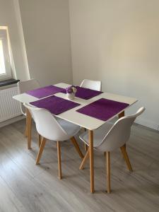 a table with white chairs and a purple table cloth at Apartament w Gdyni u podnoża Kamiennej Góry in Gdynia