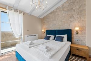 Schlafzimmer mit einem großen Bett mit blauem Kopfteil in der Unterkunft Villa Grivičić in Nova Vas