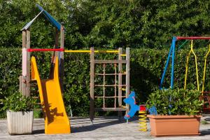 un parque infantil con tobogán y columpio en Hotel Donatello en Alberobello