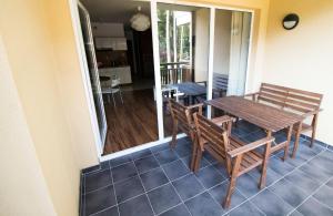 um alpendre com uma mesa de madeira e cadeiras numa casa em Natura Resort em Pogorzelica