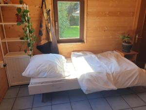 1 cama con sábanas blancas en una habitación con ventana en Homestay Sleepy Traveler, en Sankt Georgen im Attergau