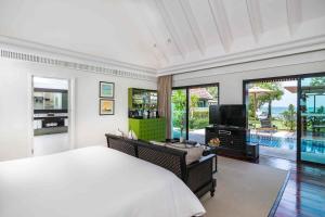 InterContinental Koh Samui Resort, an IHG Hotel في شاطئ تالينغْنام: غرفة نوم بسرير كبير وتلفزيون فيها