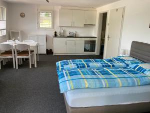 a bedroom with a bed and a kitchen and a table at FeWo-Studio Linde in Amsoldingen