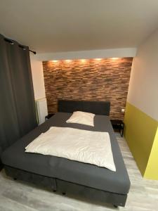 a bedroom with a bed and a brick wall at Silvio-Gesell-Tagungsstätte in Wuppertal