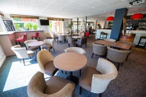 a restaurant with tables and chairs in a room at Hostellerie Saint Vincent Beauvais Aeroport in Beauvais