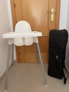 einen weißen Tisch und eine schwarze Tasche neben einer Tür in der Unterkunft Casa Milo in Nerja