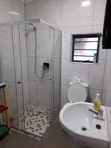 a bathroom with a shower and a toilet and a sink at The Hideout in Port Shepstone