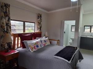 a bedroom with a bed and a bathroom with a sink at The Hideout in Port Shepstone