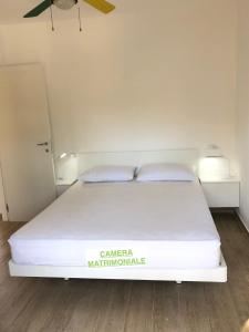 Un dormitorio con una cama con sábanas y almohadas blancas. en TARTANA, en Lignano Sabbiadoro 13 fotos más