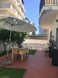 a patio with a table and an umbrella at Sinilu a mare in Montesilvano