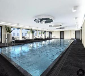 a large swimming pool in a building with chairs at Apartament Premium Kołobrzeg, Hotel Solny in Kołobrzeg