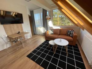 un soggiorno con divano e tavolo di Apartman 511 a Lipno nad Vltavou