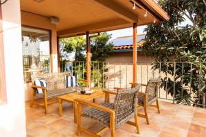 une terrasse couverte avec une table et des chaises en bois. dans l'établissement Las Olas by AvantStay Panoramic Ocean Views in the heart of Point Loma, à San Diego